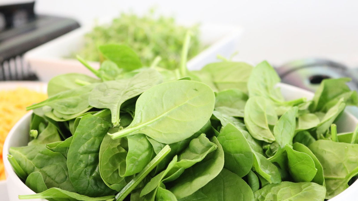 Fresh spinach leaves in a white bowl
