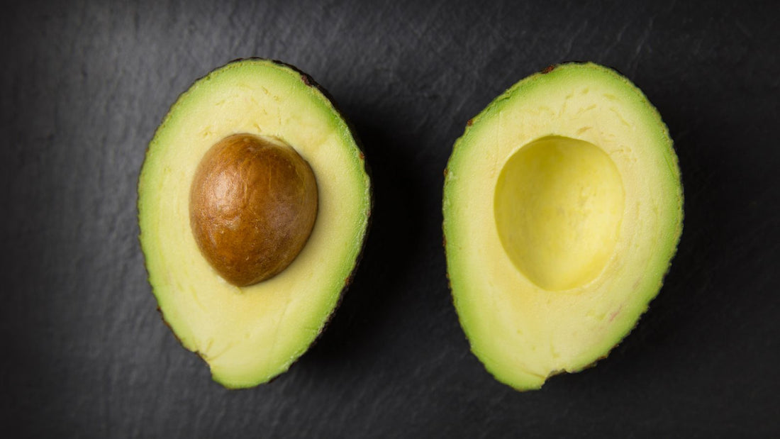 Halved fresh avocado showing the pit