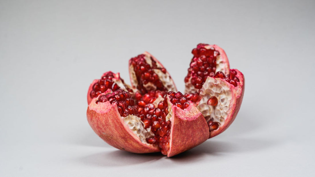 A ripe pomegranate split open showing its red seeds